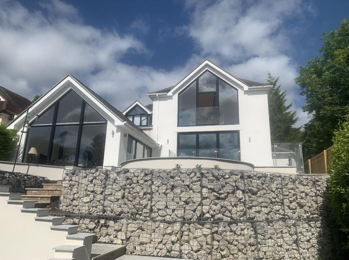Granite paving, gabion baskets and rendered walls at a garden in Bledlow Ridge