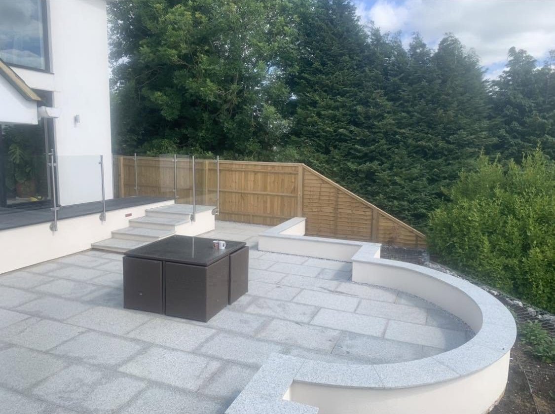 Curved rendered seating wall and granite terrace in Bledlow Ridge